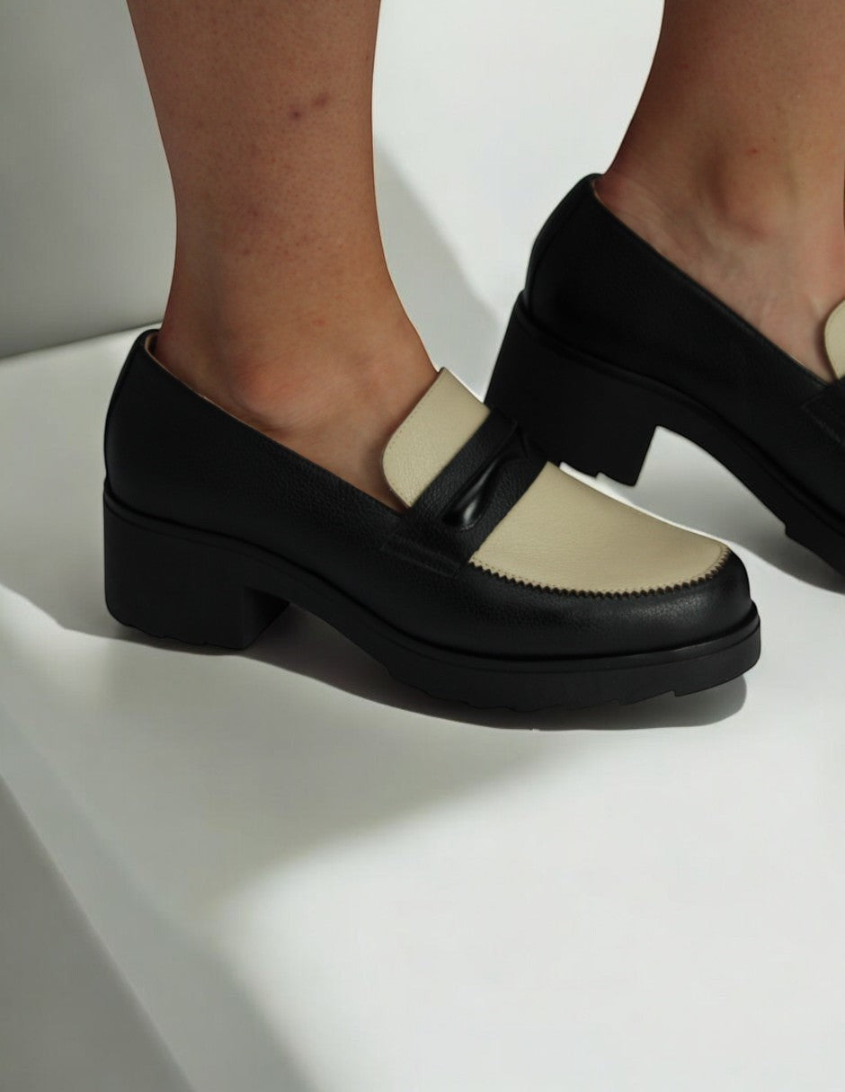 Manet black and cream leather loafers with a block heel and decorative bow detail. Classic style.