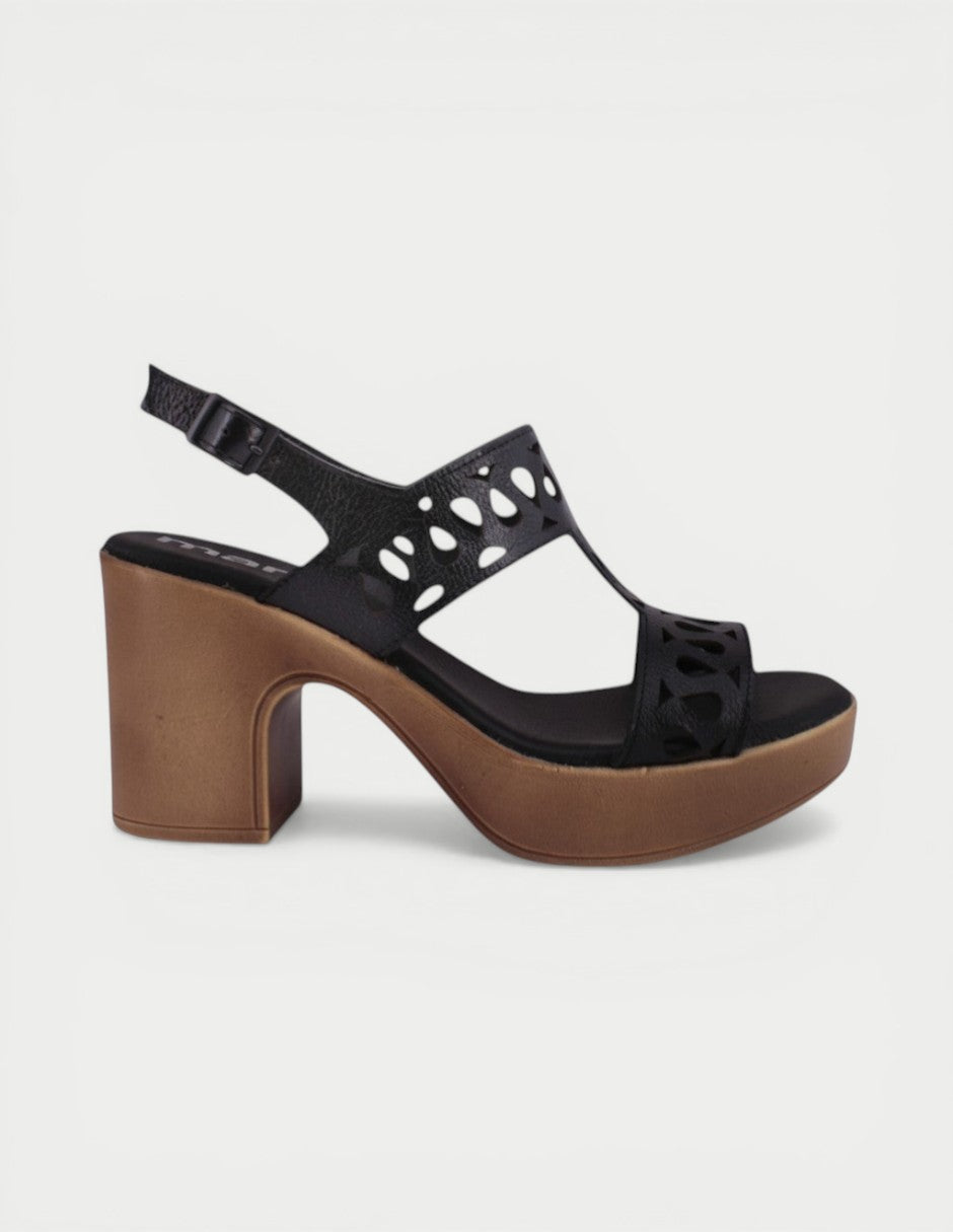 Manet black leather platform sandals with cut-out details and a chunky wooden-look heel. Adjustable ankle strap for comfort.